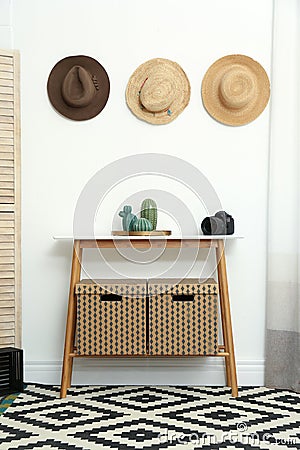 Stylish wooden table with boxes at white wall Stock Photo