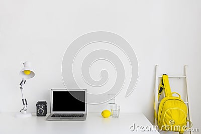 Stylish workplace white yellow colors with backpack laptop. High quality and resolution beautiful photo concept Stock Photo