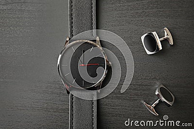 Stylish wrist watch and cuff links on wooden background, top view Stock Photo