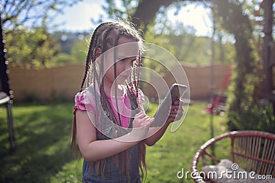 Girl chatting with friends with smartphone, virtual game during lockdown and after, new normal Stock Photo