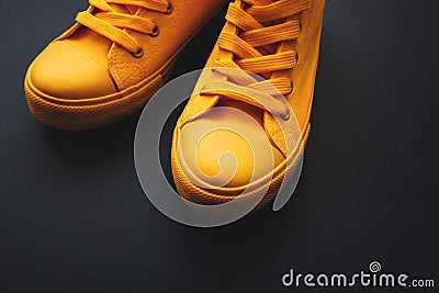 Stylish yellow sneakers on dark background Stock Photo