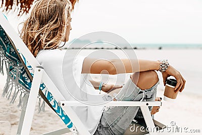 Stylish young beautiful woman in casual wear relaxing in chair o Stock Photo