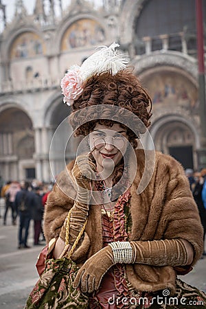 Stylish young lady dressed in opera-cloack, gloves and XIX style dress with a wig on her head and lorgnette in her hand Editorial Stock Photo