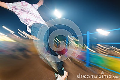 Stylish young skater in a fashionably tucked hat rides a skatepark at night. Night photo with the movement of lights and Stock Photo