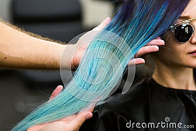Stylist demonstrates his work with Beautiful girl. Barber haircut dyed hair color blue Stock Photo