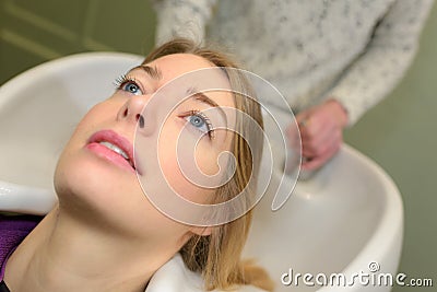 Stylist washing and combing woman hair in hairsalon pool Stock Photo