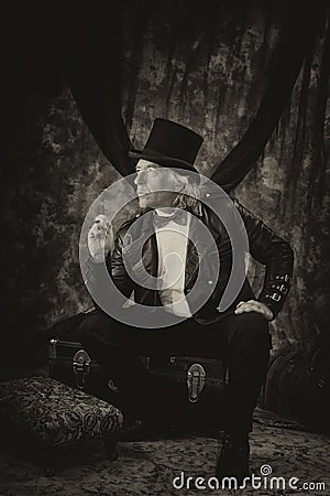 Antiqued steampunk portrait of man sitting on trunk Stock Photo