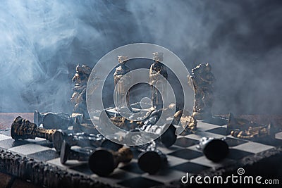 Stylized chess pieces on a board with black background, smoke and selective focus Stock Photo