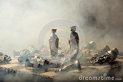 Stylized chess pieces on a board with orange background, smoke and selective focus Stock Photo