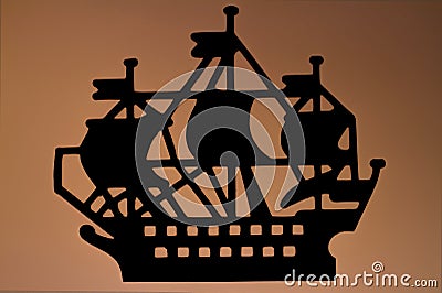 Stylized silhouette of a sailing ship on a brown background. Stock Photo