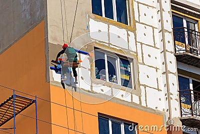 Styrofoam insulation of high-rise building. Rope access working. Concept of industrial alpinism Editorial Stock Photo