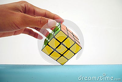 Man holding a rubik's cube on white background. 3x3 Rubik's cube Editorial Stock Photo