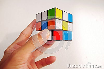 Man holding a rubik's cube on white background. 3x3 Rubik's cube Editorial Stock Photo