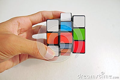 Man holding a rubik's cube on white background. 3x3 Rubik's cube Editorial Stock Photo