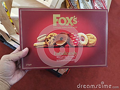 Subang Jaya,Malaysia - 28 October 2018 : Hand hold box of FOX'S Fabulously Biscuit Selection for sell in the supermarket Editorial Stock Photo