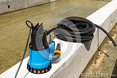 Submersible pump dewater construction site, pumping flood water sing deep well. Stock Photo