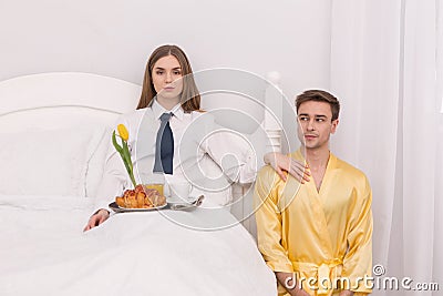 Submissive boyfriend bringing breakfast to his girlfriend Stock Photo