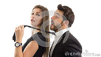Wife pulls her husband by the tie. She is smiling. Submissive husband.. Stock Photo