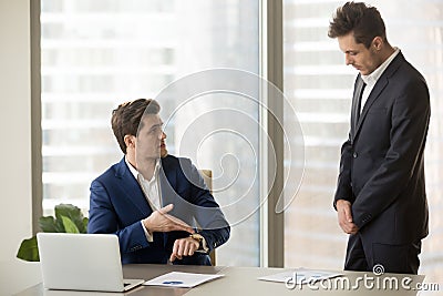 Subordinate receiving reprimand from boss for being late, missin Stock Photo