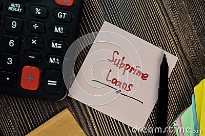 Subprime Loans write on sticky notes isolated on Wooden Table. Finance concepts Stock Photo