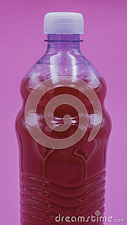 Red detergent or disinfectant inside a transparent plastic bottle on a lilac background Stock Photo