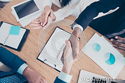 Success and agreement between three business partners, they celebrate sitting in workplace, workstation, wearing suits, men Stock Photo