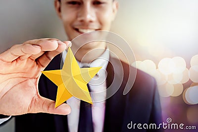 Success in Business or Personal Talent Concept. Happy Businessman in black suit Smiling and Showing a Golden Star in Hand Stock Photo