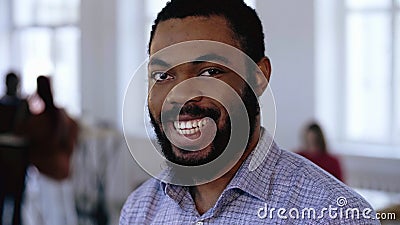 Success and luck concept. Close-up portrait of young black manager businessman winking, posing at modern trendy office. Stock Photo