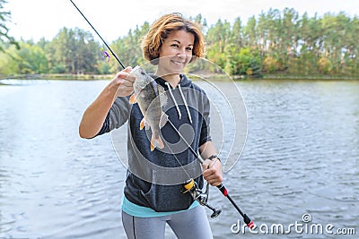 Success perch fishing. Lady fisherwoman with fish at lake Stock Photo