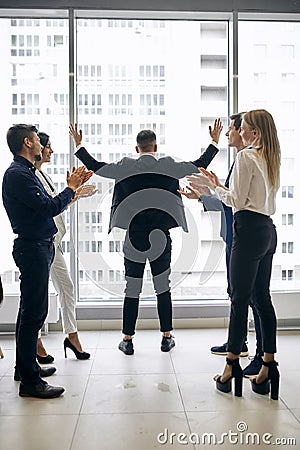 Successful ambitious businessman celebrating a triumph with arms up Stock Photo