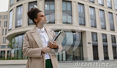 successful ambitious woman of African American appearance in business clothes with a laptop in her hands against the Stock Photo