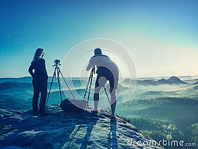 Successful artist is taking pictures with camera in hills Stock Photo