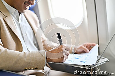 Successful Asian businessman manages his business financial paperwork on the flight. close-up Stock Photo