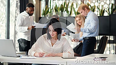 Young exuberant female office worker looking at camera with lovely smile at her workplace in meeting room Stock Photo
