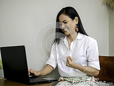 Successful beautiful asian entrepreneurs achieving goals, raising hand in fists with exciting and smiling face Stock Photo