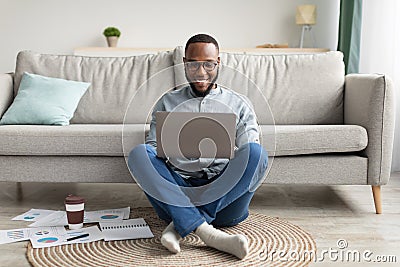 Successful Black Millennial Man Using Laptop Working Online At Home Stock Photo