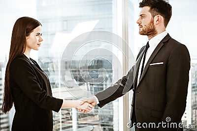 Successful business concept. Young businesswoman and businessman shake hands after signing partnership cooperation Stock Photo