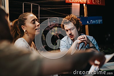 Successful Business Partners Analyzing Project Details in Evening Meeting Stock Photo