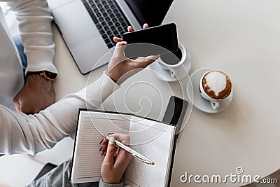 Successful business people working remotely at a laptop while sitting at a table in a cafe. Man and woman managers Stock Photo