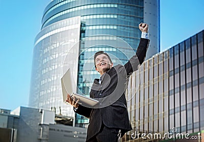 Successful businessman with computer laptop happy doing victory sign Stock Photo