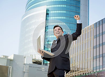 Successful businessman with computer laptop happy doing victory sign Stock Photo