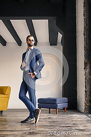 Successful businessman. Full height view of attractive bearded businessman in stylish suit at office Stock Photo