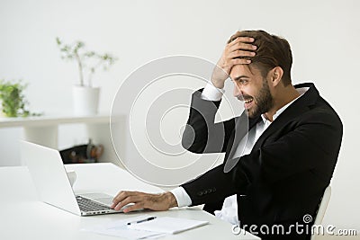 Successful businessman shocked by unbelievable online win lookin Stock Photo