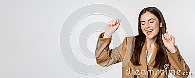 Successful businesswoman, saleswoman dancing and having fun, wearing office suit, posing over white background Stock Photo