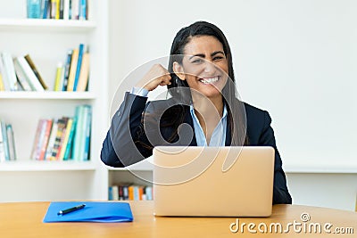 Successful cheering hispanic mature businesswoman at computer Stock Photo