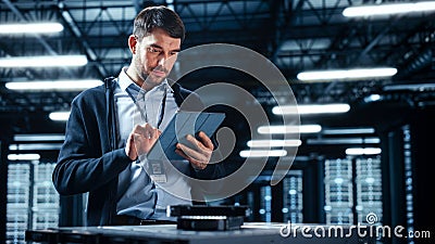 Successful Data Center IT Specialist Using Tablet Computer. Server Farm Cloud Computing Facility Stock Photo