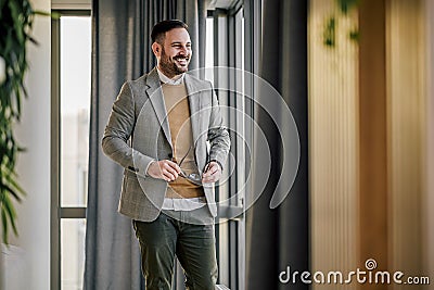 Successful happy entrepreneur in formals looking through window at office Stock Photo