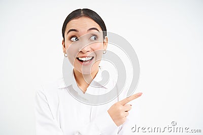 Successful korean businesswoman, pointing finger right, showing advertisement on banner, standing over white background Stock Photo