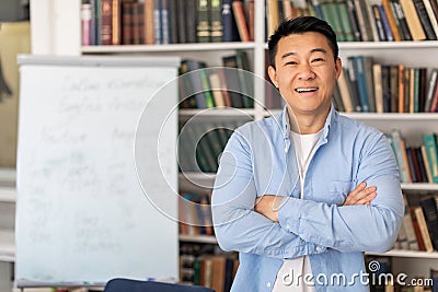 Successful Korean Teacher Man Posing Near Whiteboard Standing In Classroom Stock Photo
