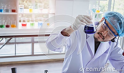 A successful male chemist is examining his new innovation in a laboratory. Stock Photo